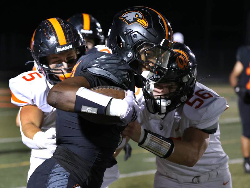 DeKalb's Davon Grant is pushed out of bounds by Lincoln-Way West's Noah Wendt (left) and Austin Collins during their game Friday, Oct. 3, 2025, at DeKalb High School.