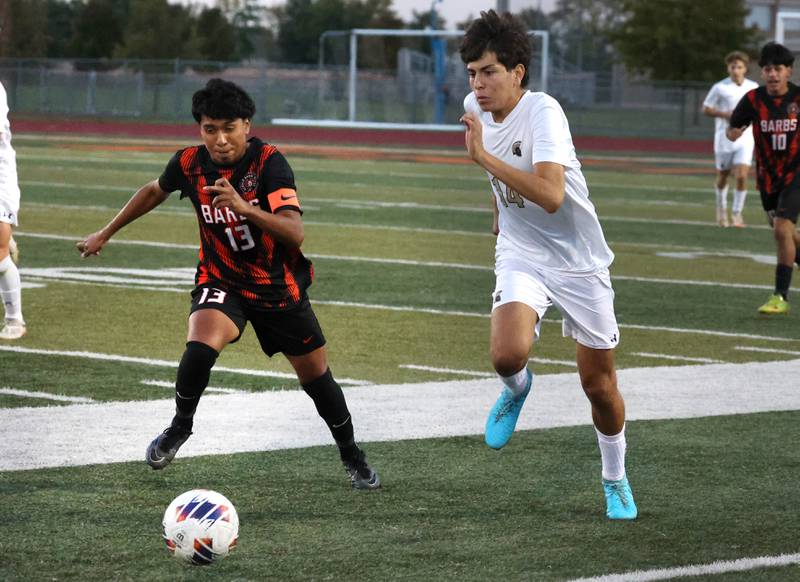 DeKalb's Henry Garcia-Alvarez (left) and Sycamore's Javier Lopez race to the ball during their game Thursday, Oct. 10, 2024, at DeKalb High School.