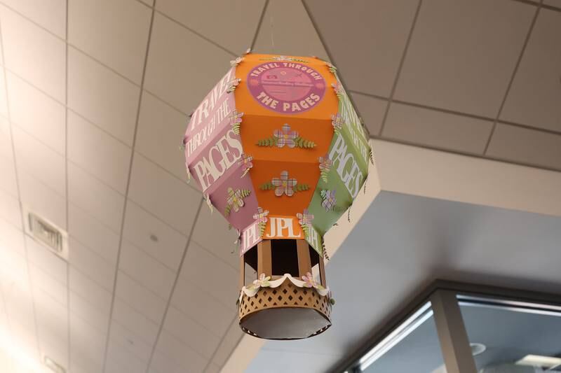 Jan Stack’s hand crafted hot air ballon hangs in the Joliet Public Library Black Road Branch for their Travel Through the Pages summer reading program on Thursday May 30, 2024 in Joliet.