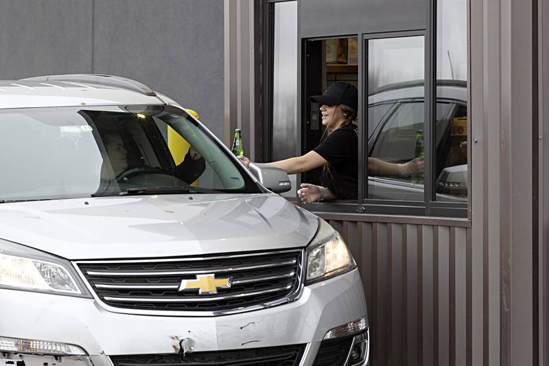 An employee hands an order to a customer Friday, Dec. 29, 2023 at the newly opened Dixon Chipotle.