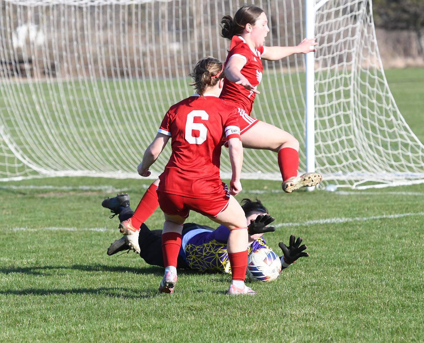 Hinckley Big Rock goalkeeper Danielle Rankin dives on the ball as two Oregon players Alyssa Mowry (6) and Anna Stender (2) move in on the play during a Monday, April 10 game at Oregon Park West.