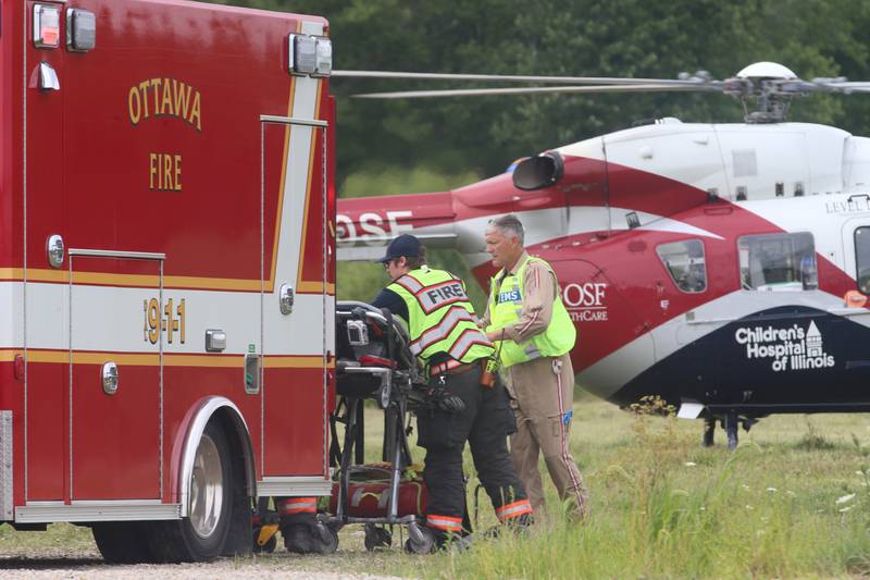 Ottawa firefighters prepare to load a patient into the OSF Lifeflight helicopter after a multiple vehicle crash a mile east of the Route 71 and Interstate 80 interchange on Wednesday, Aug. 2, 2023, near Ottawa.