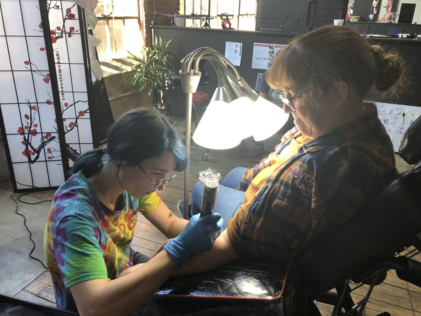 Cat, one of Irezumi's artists, works on tattooing customer Theresa Love at Irezumi Tattoo Parlor in Peru on Saturday, Oct. 29, 2022.