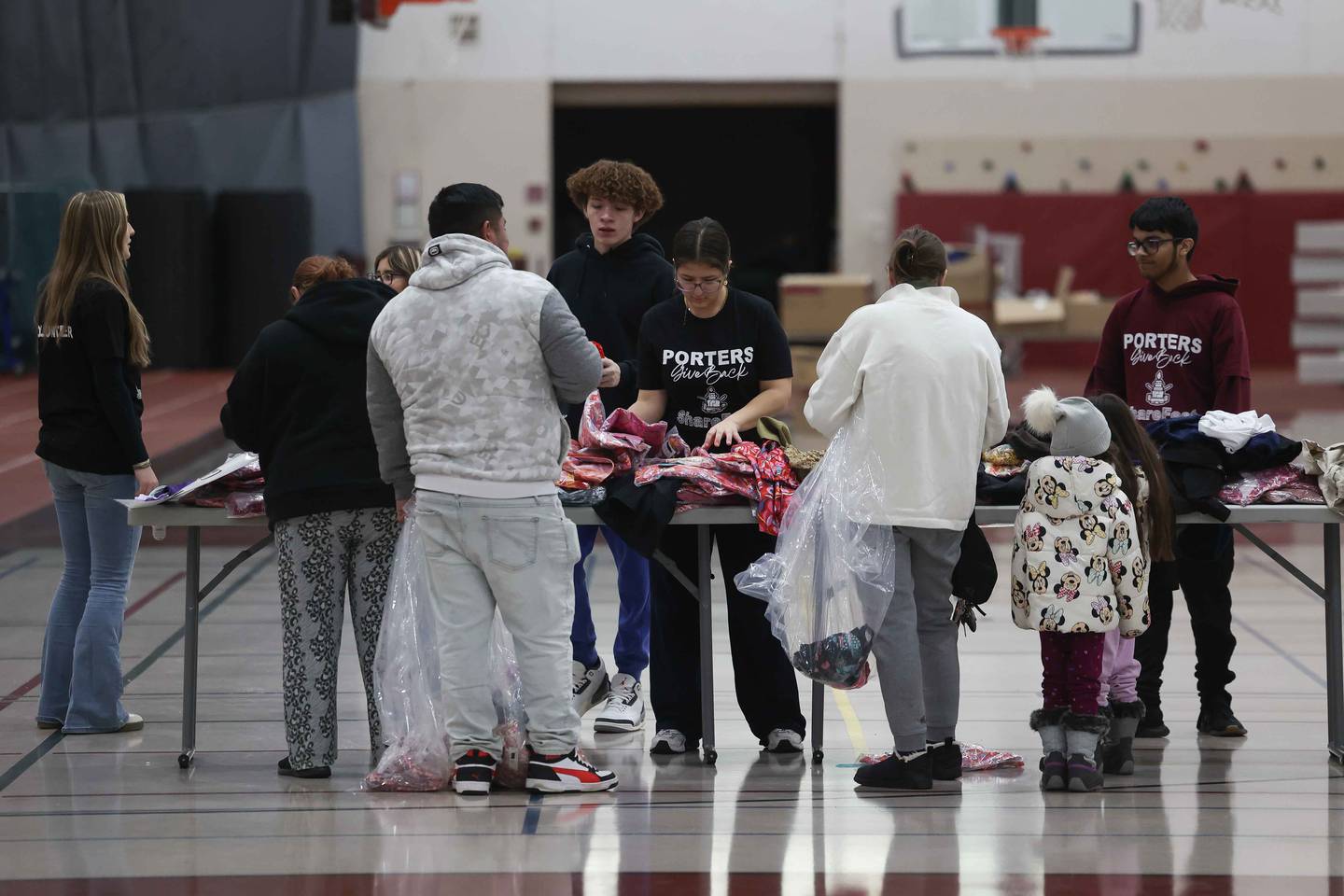 Lockport High School students help a family gather clothing at ShareFest at Lockport Township High School East campus on Sunday, Dec. 15, 2024.