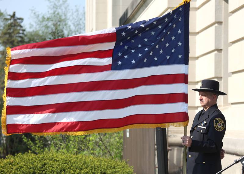 DeKalb County Sheriff's Sergeant Tim Duda holds the flag Friday, May 13, 2022, during the DeKalb County Law Enforcement Officers' Memorial Service on the lawn of the DeKalb County Courthouse in Sycamore.