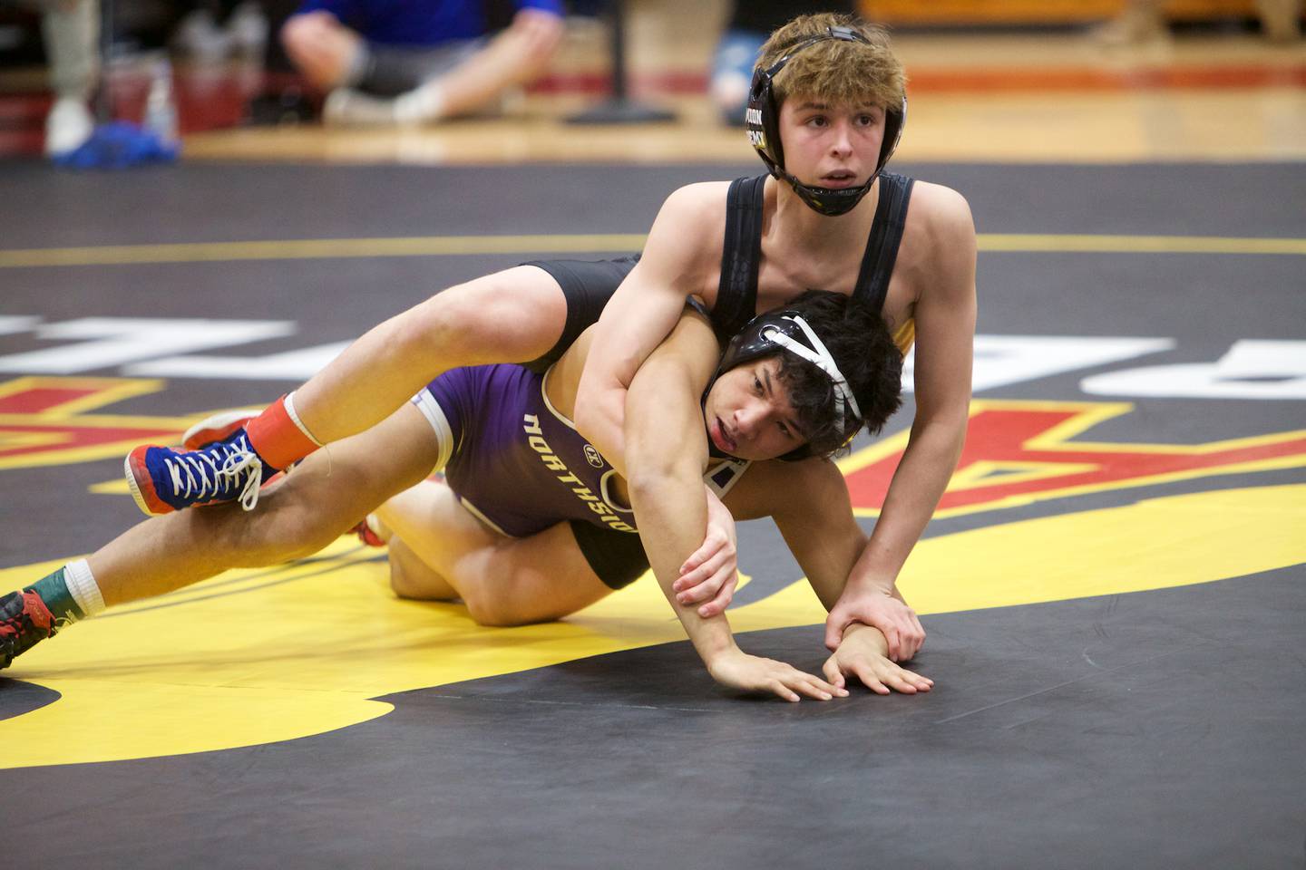 Marmion's Aidan McClure competes against Downers Grove North's Tyler Tiancgo in the 120 lb weight class at the Clint Arias Invitational on Saturday, Jan.18,2025 in Batavia.