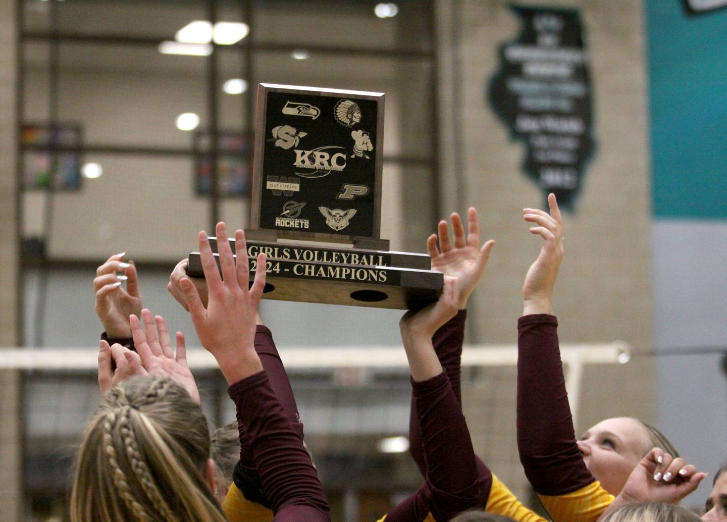 Richmond Burton’s Rockets hoist their hardware after a conference-clinching win in varsity volleyball action at Woodstock North High School in Woodstock on Wednesday, Oct. 16, 2024.
