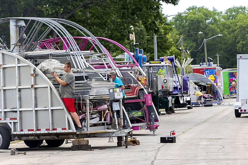 Workers get busy constructing the rides and attractions Monday, July 1, 2024, for the 60th Petunia Festival in Dixon. The carnival will open Wednesday at 5 p.m.
