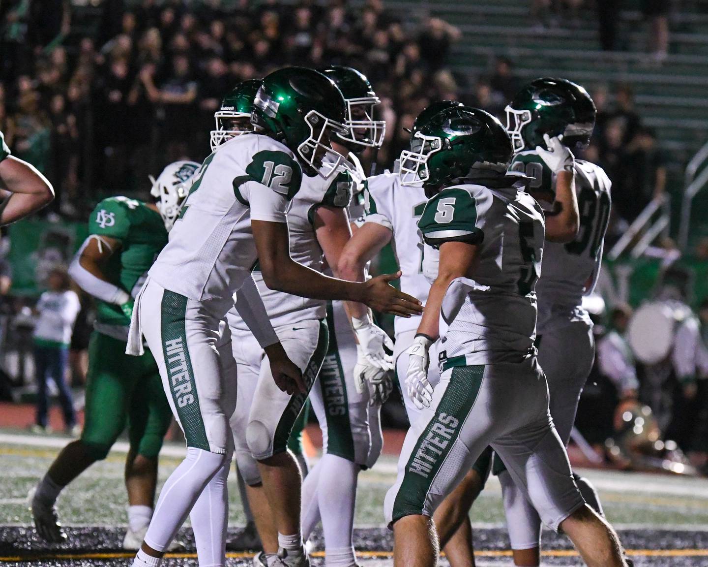 Glenbard West's Max Hetlet, right, gets congratulated by teammate Glenbard West's AJ Rayford (12) after Max scored a touchdown during the game on Friday Oct. 17, 2025, held at York High School.