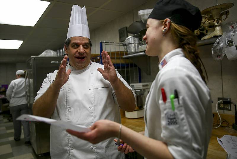 Chef Andy Chlebana speaks April 16 with his lab assistant Brooke Hoekstra while helping the rest of his students to prepare a series of deserts at Joliet Junior College Renaissance Center in Joliet.