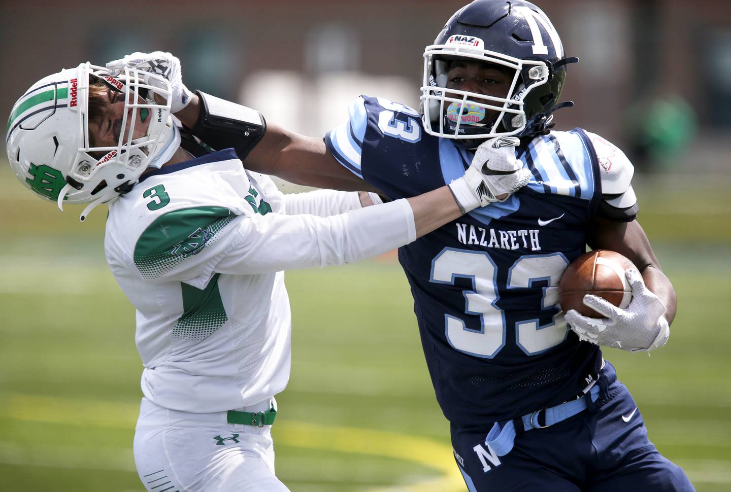 Nazareth’s Patrick Oden protects the ball from Notre Dame’s Jake DeFranza during their football game at Nazareth Academy in LaGrange Park, Ill., on Saturday, April 17, 2021.