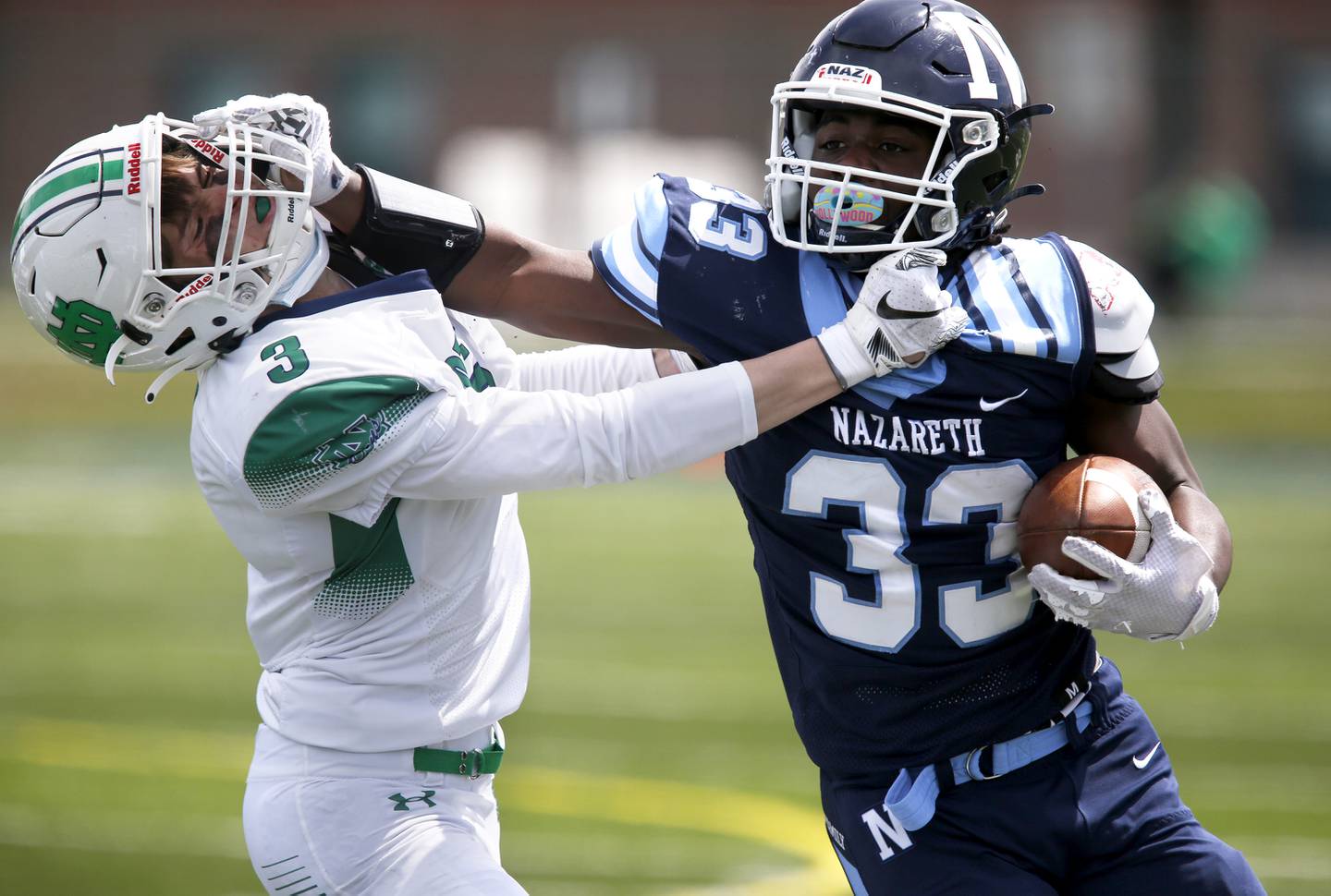 Nazareth’s Patrick Oden protects the ball from Notre Dame’s Jake DeFranza during their football game at Nazareth Academy in LaGrange Park, Ill., on Saturday, April 17, 2021.