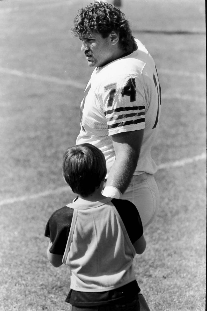 Chicago Bears offensive lineman Jim "Jimbo" Covert talks to a child during training camp on Wednesday, June 12, 1985 in Platteville Wis.