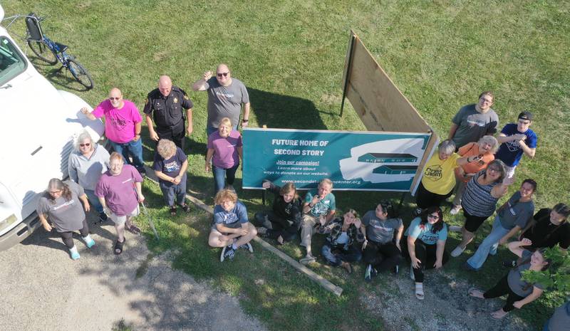 Volunteers and community members pose for a photo where the future home of the Second Story Teen Center will be built at the intersection of Crown Street and South Main Street on Wednesday, Aug. 16, 2023 in Princeton.