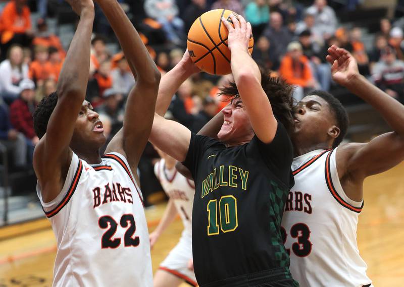 Waubonsie Valley's Josh Tinney tries to score between DeKalb's Justin O'Neal (left) and Davon Grant during their game Friday, Feb. 21, 2025, at DeKalb High School.