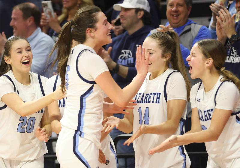 Nazareth's Sophia Towne hi-fives teammates (from left) Fiona Ryan, Audrey Wendt and Elena Vlahos during the Class 4A State girls basketball championship game on Saturday, March 7, 2026 at CEFCU Arena in Normal.