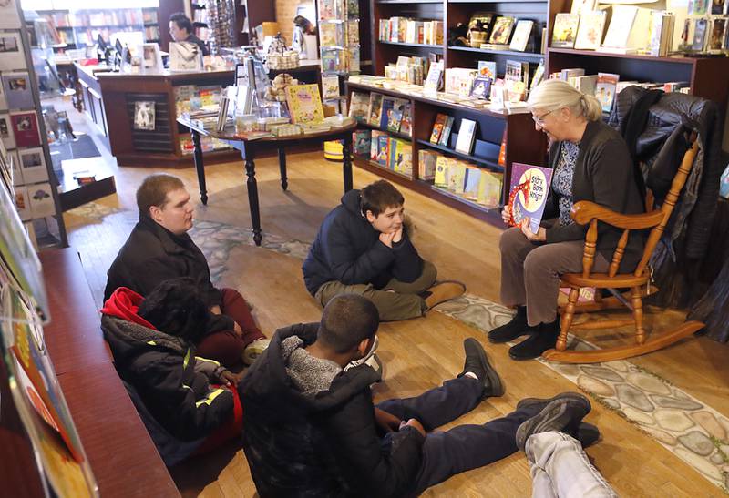 Bette Chwalisz, a retired teacher, reads a book on Thursday, Feb, 20, 2025, at Read Between The Lynes in Woodstock as students in a life skills class at Menta Academy Woodstock listen to the story during the bookshop's weekly story time.