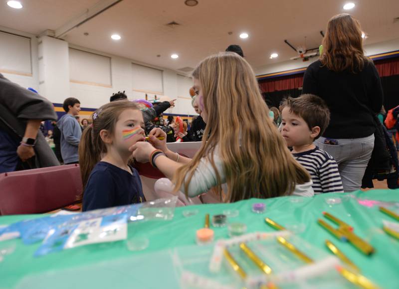 Forest Road fourth grader paints the faces of Barnsdale students (left) Maddie and Beckett Cunningham while they attend the St. Baldrick fundraiser held Thursday, March 7, 2024.