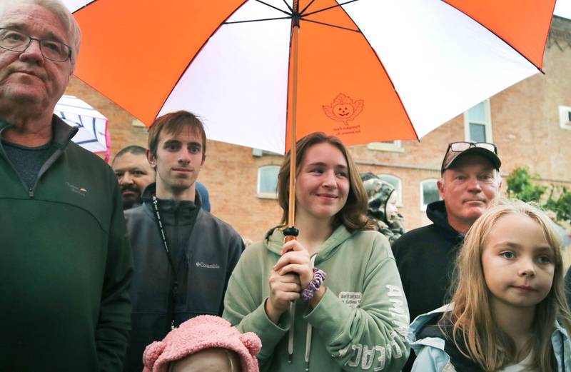 Lydia Schoenthal, 17, from Sycamore, holds an umbrella during the cake cutting Wednesday, Oct. 25, 2023, on North Maple Street adjacent to the DeKalb County Courthouse during the Sycamore Pumpkin Festival.
