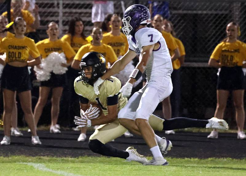 Sycamore's Josiah Mitchell comes up with a one-handed catch in front of Rochelle's Mark Green on Sycamore’s first play from scrimmage during their game Friday, Sept. 19, 2025, at Sycamore High School.