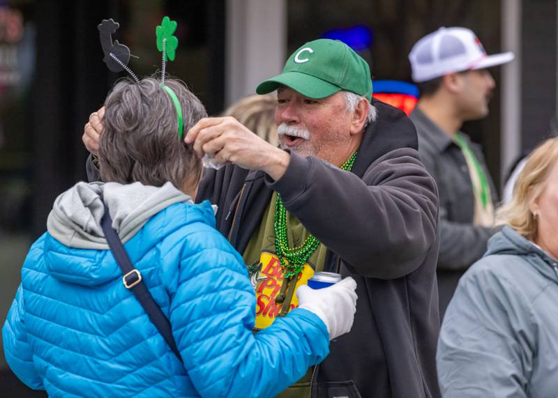 Rick Plochocki smiles as he places a shamrock headband on his wife Lori's head during the St. Patrick's Day Parade on March 7, 2026 in Utica.