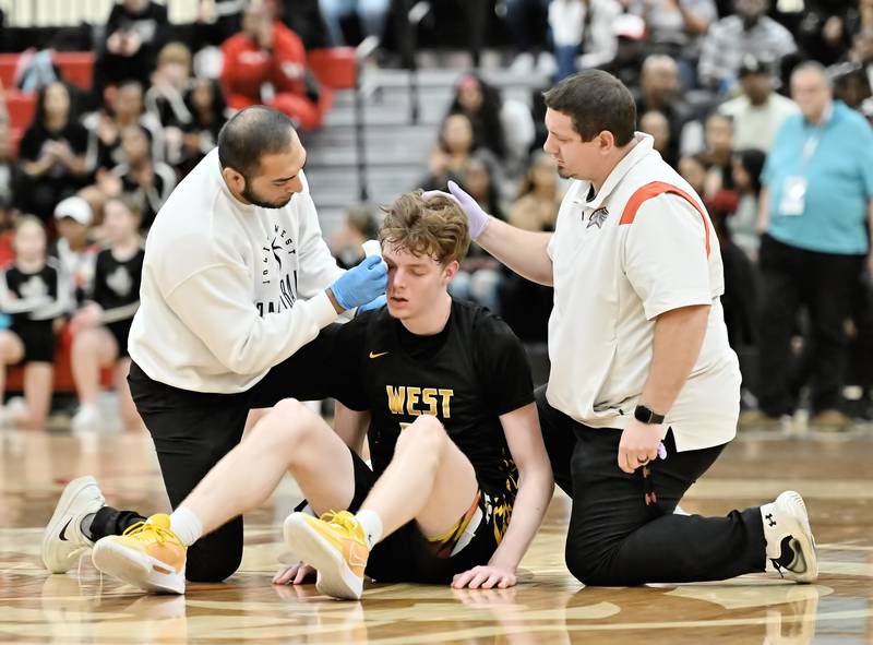 Joliet West's Drew King getting treatment by the team trainer  during the Class 4A sectional semifinal against Homewood Flossmoor at Rich Township on Tuesday, Feb. 27, 2024, at Richton Park. (Dean Reid for Shaw Local News Network)