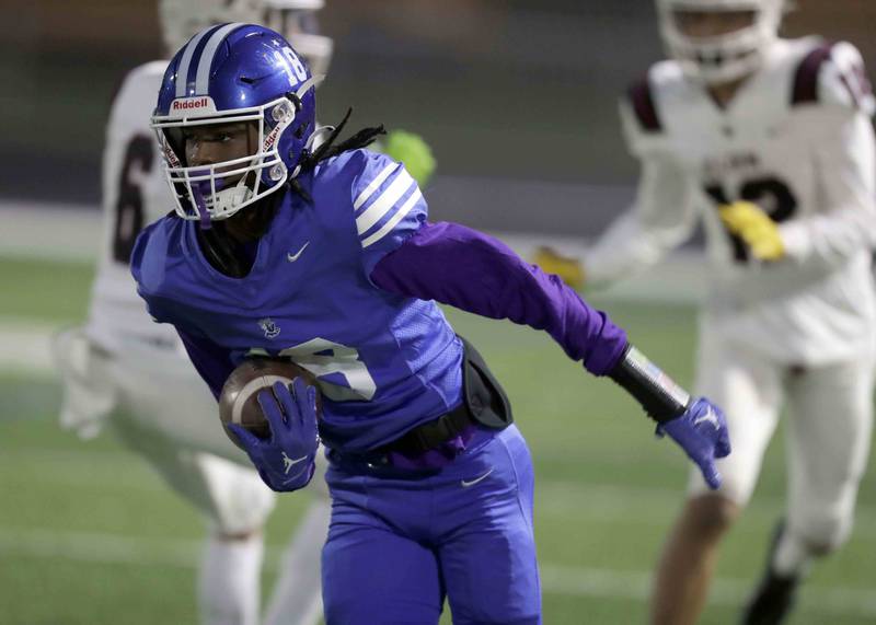 Larkin's Erick Myrick (18) moves upfield after bringing in an interception during the annual crosstown rival game at Memorial Field  Friday October 14, 2022 in Elgin.