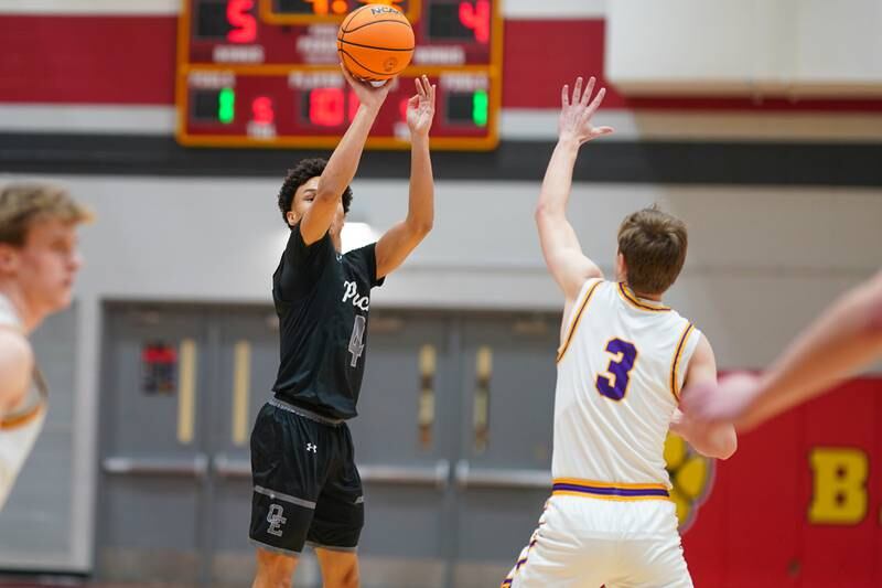 Oswego East's Myles Buchanan (4) shoots a three pointer against Downers Grove North's Nolan Hurter (3) during a Batavia Night of Hoops Basketball game at Batavia High School on Saturday, Jan. 25, 2025.