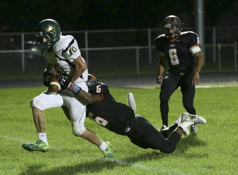 Crystal Lake South Scott Coughlin (10) scores a touchdown as Crystal Lake Central's Aaron Sances (6)  hangs on during the fourth quarter of their game at Crystal Lake Central High School on Saturday, September 19, 2015 in Crystal Lake. The Gators defeated the Tigers 28-14.