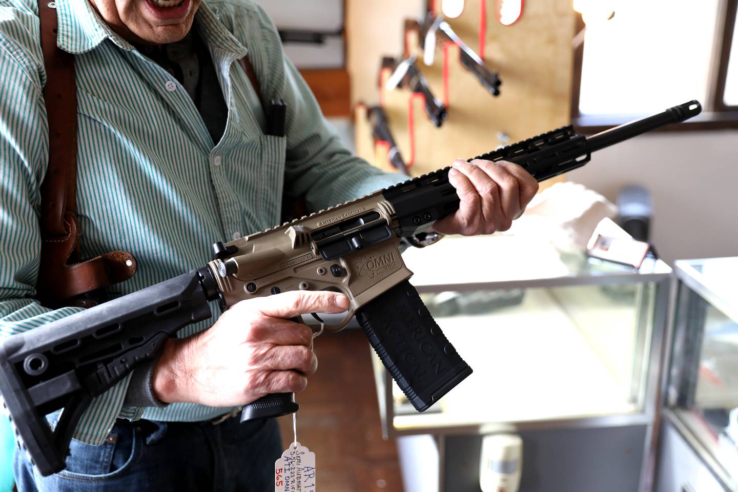 Manny Segarra of St. Charles holds the AR-15 rifle no longer for sale at his store, Manny Segarra Guns in West Chicago, on Wednesday, Jan. 11, 2023. Illinois Gov. JB Pritzker signed a bill Tuesday, Jan. 10, 2023 banning the purchase, sale and manufacture of high powered semi-automatic weapons, .50 caliber rifles and ammunition, and large-capacity magazines in the state while still allowing people who already own such weapons to keep them.