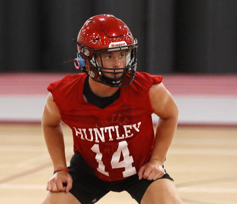 Huntley’s Joe Arvidson looks in a the ball during a defensive drill during the first day of football practice Monday, 8, 2022, in the Huntley High School  field house after stormy weather move practice inside.