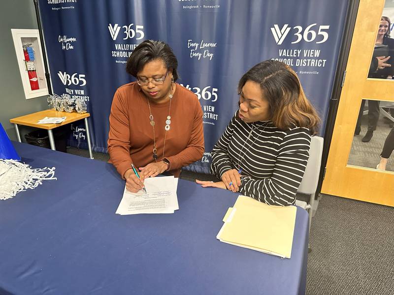 Valley View School District  Paraprofessional Dana Gilbreath signs her commitment to the VVSD Elevate U program with VVSD Director of Human Resources Dr. Rovel Pollock.