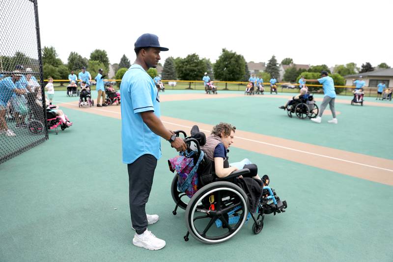 Kane County Cougars outfielder Armond Upshaw partners with Marklund client Brenda during a softball game at Marklund Hyde Center in Geneva on Tuesday, July 9, 2024.
