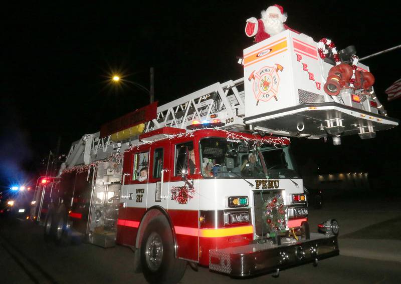 Santa Claus waves to children during the annual Christmas Parade on Saturday, Dec. 7, 2024 on Peoria Street in Peru.