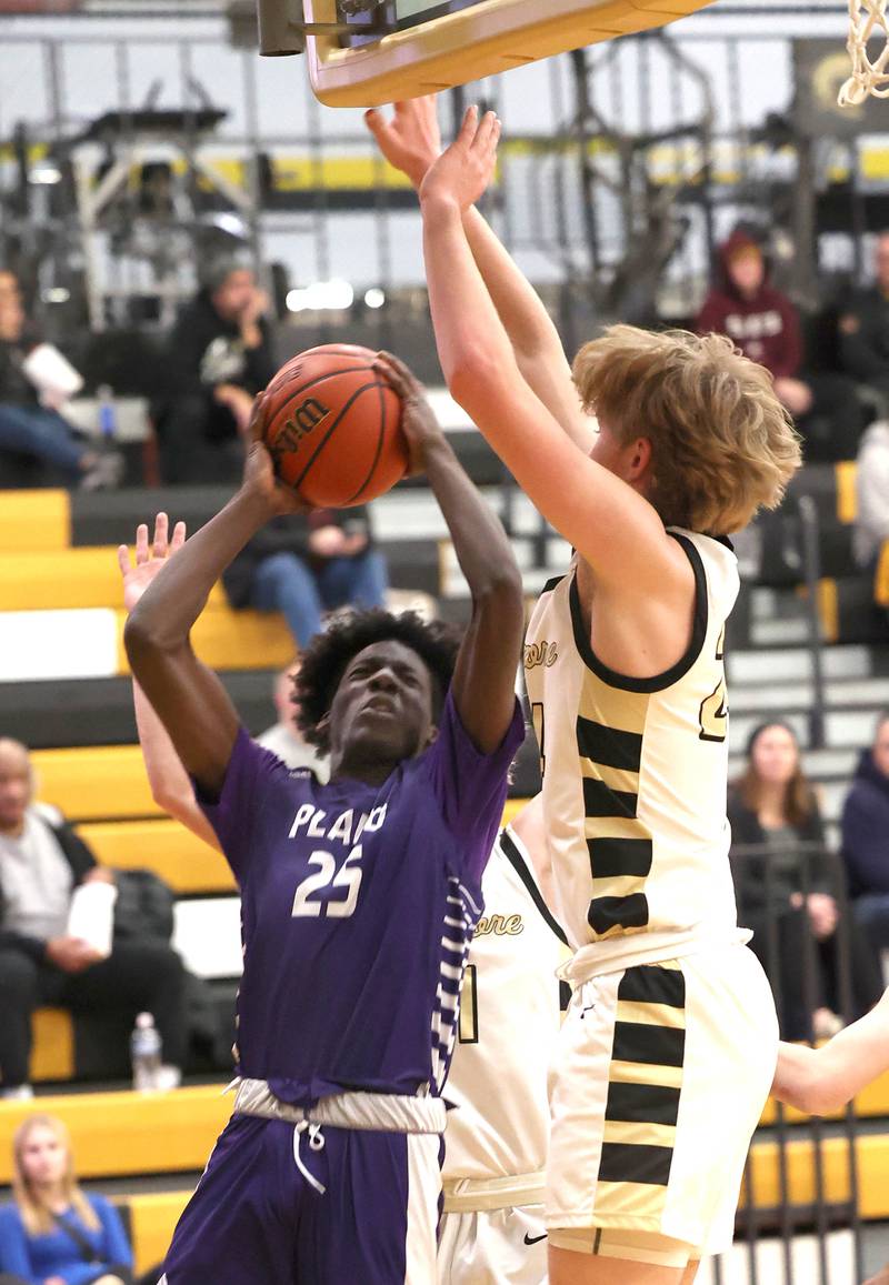 Plano's Christ Keleba tries to get up a shot over Sycamore's Lucas Winburn Tuesday, Jan. 3, 2023, during their game at Sycamore High School.