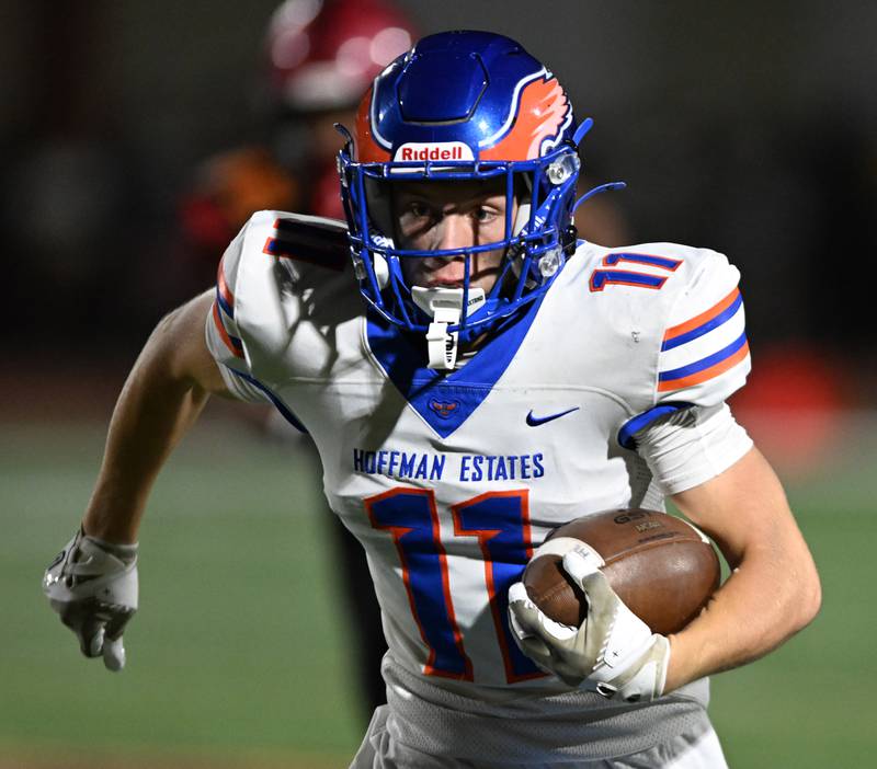 Hoffman Estates’ TJ Bond carries the ball during Friday’s football game at Schaumburg.