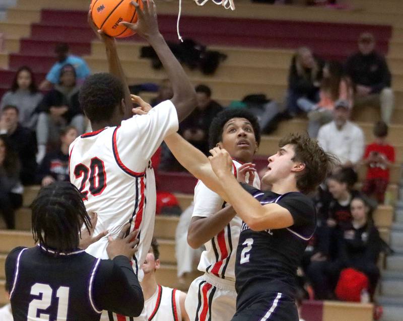 Huntley’s Isaiah Onu snags a rebound as he tussles with Hampshire’s Cole Harkin, right, in varsity boys basketball on Friday, Dec. 19, 2025, at Huntley High School in Huntley.
