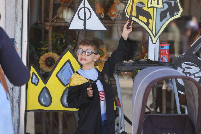 Artur Bonin, 5, of Aurora poses for a picture in front of a Harry Potter theme store front painting at the Magic in Morris event on Saturday.