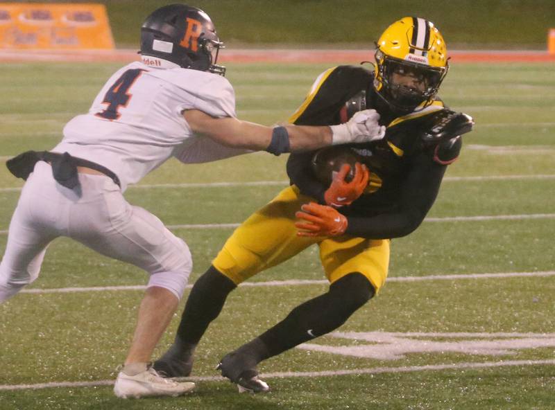 St,. Laurence's Aaron Ball runs the ball as Rochester's Jack Buecker defends during the Class 4A State football championship on Friday, Nov, 24, 2023 at Hancock Stadium in Normal.