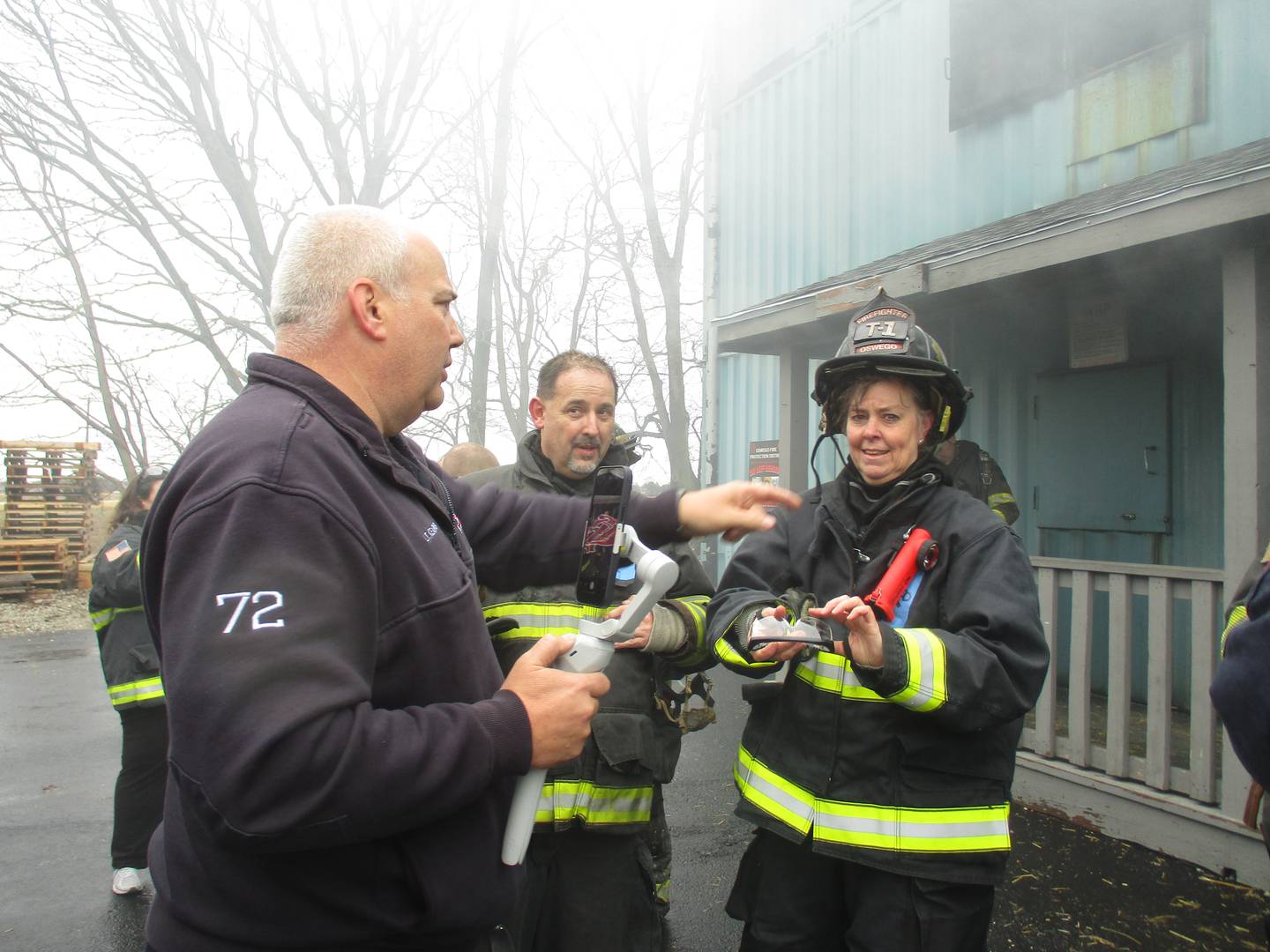 Montgomery Village Board Trustee Doug Marecek, center, and Oswego Village Board Trustee Jennifer Jones Sinnott, right, are debriefed by Oswego Fire Protection District Lt. Kris Kearns after emerging from a structure filled with smoke and flame, during a training exercise at the Montgomery station on March 19, 2022. (Mark Foster -- mfoster@shawmedia.com)