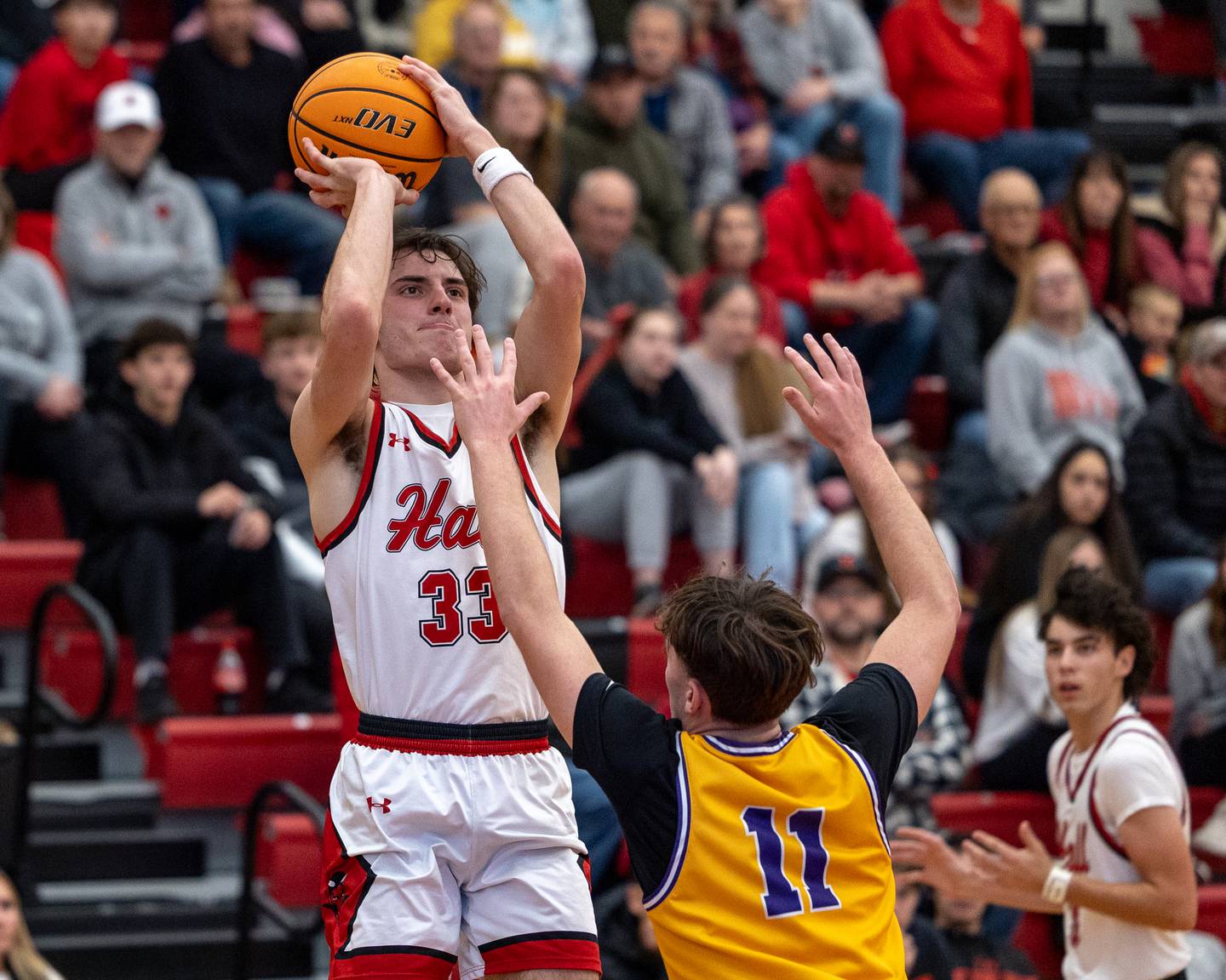 Braden Curran (33) of Hall pulls up for midrange shot over Aden Tillman (11) of Mendota holds ball up over Greyson Pickett (0) of Mendota during the championship game of the Colmone Classic on Saturday, December 20, 2025 at Hall High School in Spring Valley.