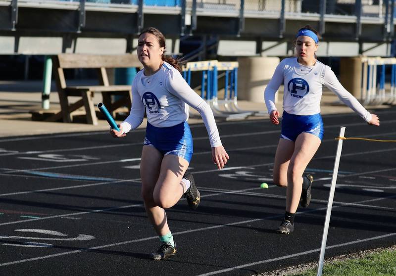 Princeton's Scarlet Fulton takes the baton from twin Georgie in Thursday's Howard-Monier Girls Invitational at Princeton.