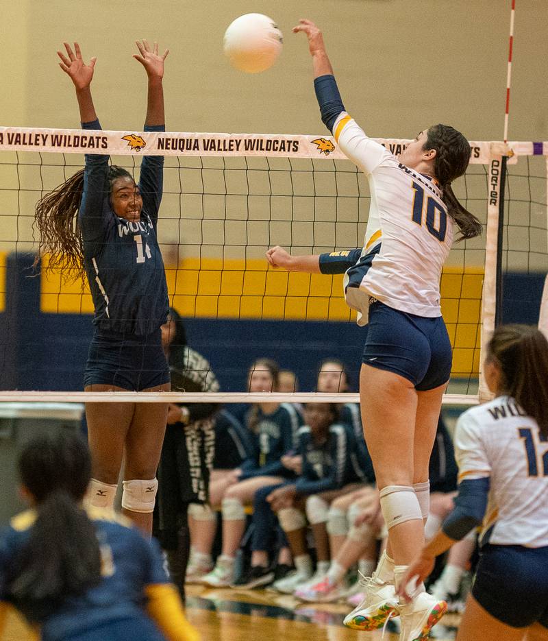 Oswego East's Cailyn Smiley (14) defends the net against a kill attempt by Neuqua Valley's Amanda Duncan (10) during the Neuqua Valley 4A regional final volleyball match at Neuqua Valley High School in Naperville on Thursday, Oct 27, 2022.