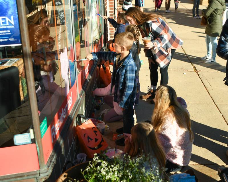 Participants paint windows on Saturday Oct. 26, 2024, during the Halloween event held in downtown Downers Grove.