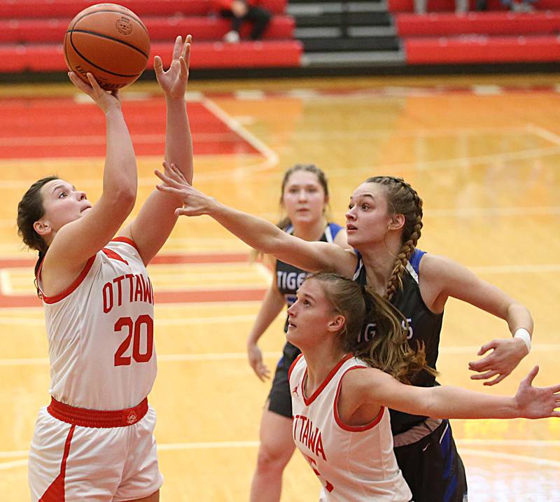 Ottawa's Kendall Lowery (left) shoots as teammate Hailey Larsen (center) sets a pick on Princeton's Kaighley Davis (right) on Thursday, Dec. 15, 2022, at Kingman Gym in Ottawa.