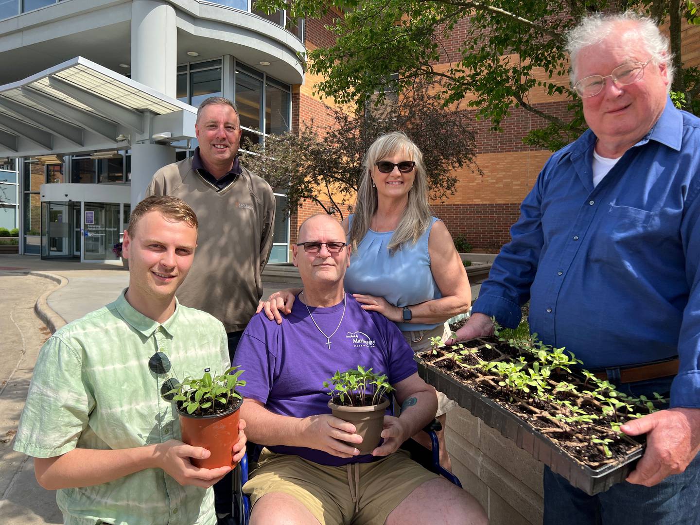 Recovering alcoholic Sean Flannery of Joliet (left) recently planted 100 sunflower seedings near the chapel at Northwestern Medicine Marianjoy Rehabilitation Hospital in gratitude for helping his father Tim Flannery of Joliet (center) recover from a motorcycle accident. Also pictured are, from left:  Jeff Jones, Marianjoy groundskeeper; Joann Flannery, Tim's wife; and Ray Ward, Marianjoy grounds supervisor.