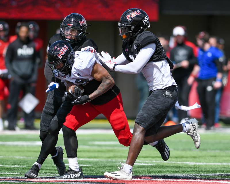 Northern Illinois University Wide receiver Isaiah Bragg, center, gets stopped by Northern Illinois University safety Jashon Prophete, right, and Northern Illinois University safety Patrick Hoffmann during a spring scrimmage on Saturday April 16th held at Huskie Stadium in DeKalb.