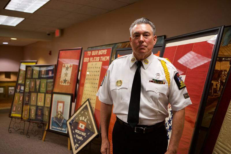 Mark Hutson with a small portion of the blue and gold star service flags and posters he and his wife, Kristine, have collected since 2012. Part of the collection is on display at the Woodstock Public Library through June 3, 2022, in Woodstock.