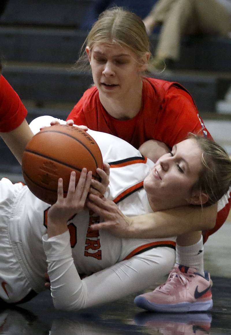 Dundee-Crown’s Monica Sierzputowski tries to grab a loos ball from McHenry's Ali Ahrens during a Fox Valley Conference girls basketball game on Tuesday, Dec. 12, 2023, at McHenry High School.