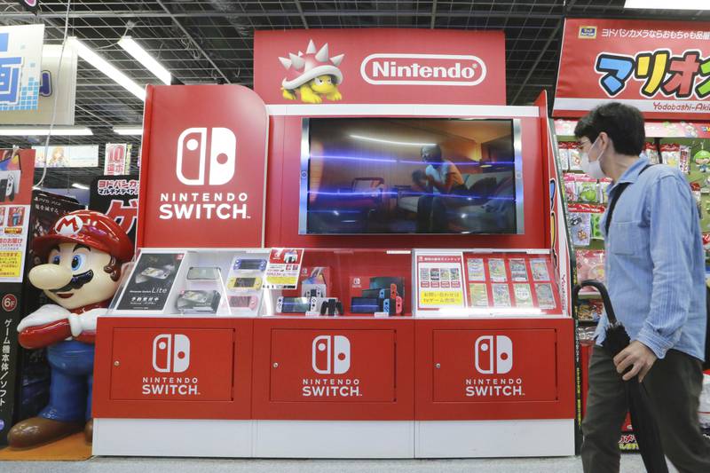 FILE - A man walks by a Nintendo Switch display at an electronics retail chain store in Tokyo, on Oct. 13, 2021. (AP Photo/Koji Sasahara, File)